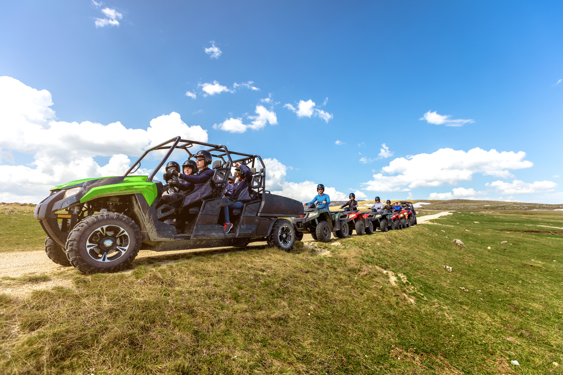 Friends driving off-road with quad bike or ATV and UTV vehicles